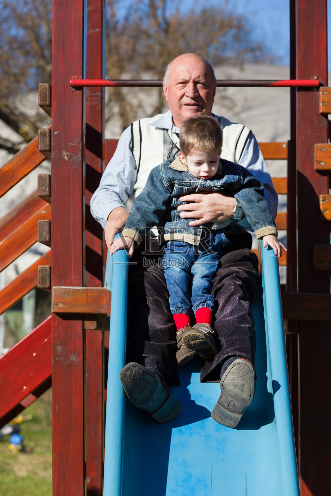 爷爷和孙子在滑梯上照片摄影图片
