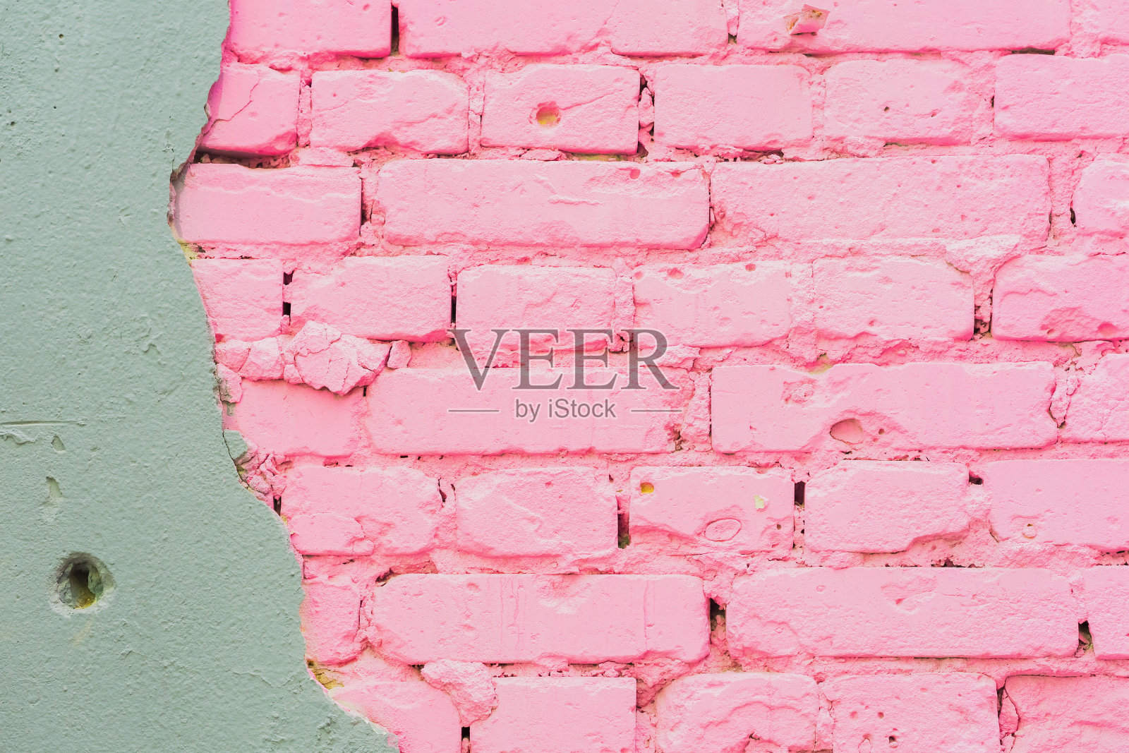 美丽抽象的背景由混凝土和涂上粉色纹理的砖墙构成城市背景，空间为文字。损坏的墙壁上露出砖照片摄影图片