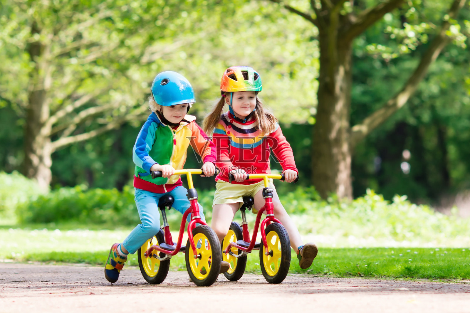 孩子们在公园里骑平衡自行车照片摄影图片