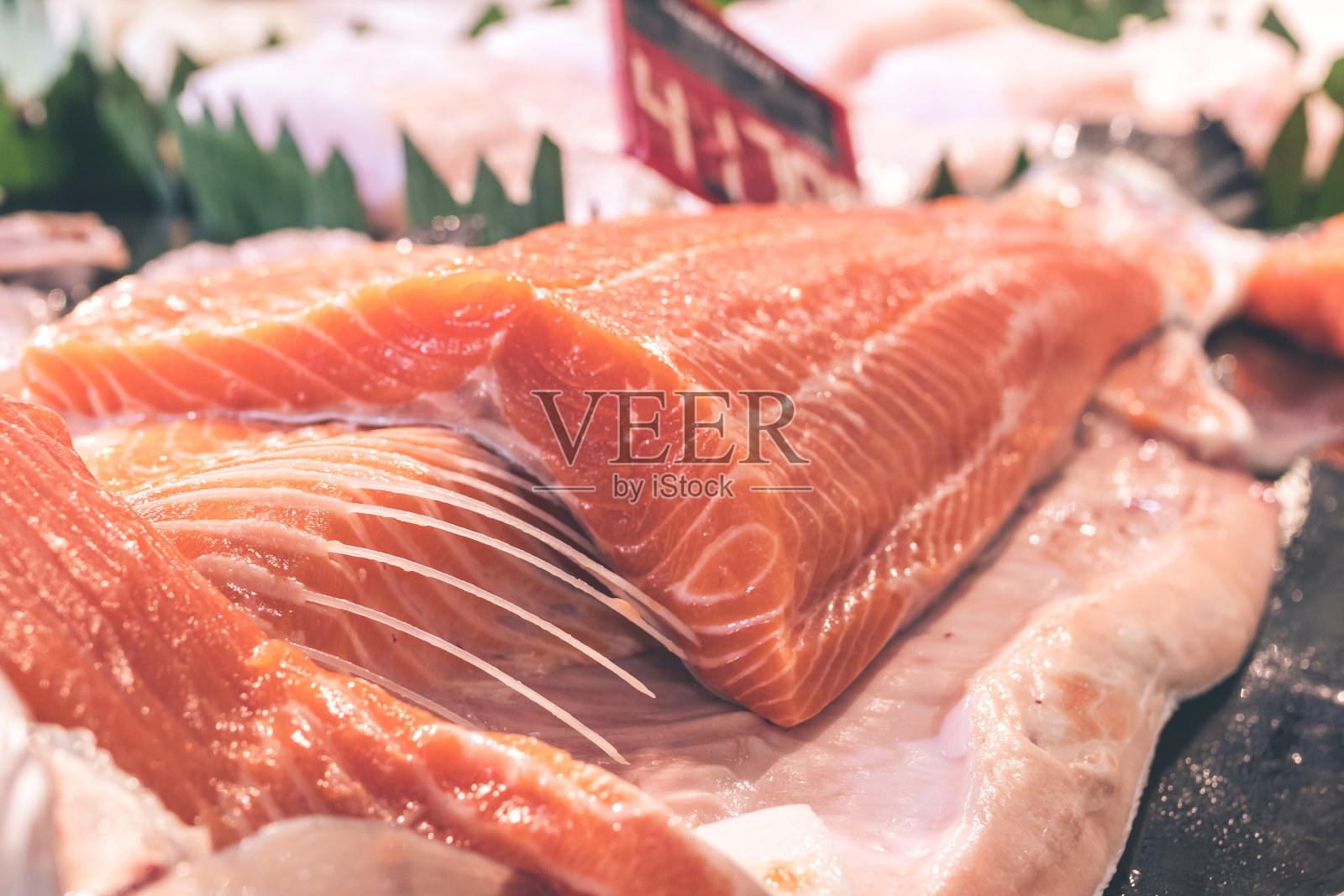 仔细观察生三文鱼片的肉质。印度尼西亚巴厘岛当地食品市场上的生鲑鱼和大西洋鱼照片摄影图片