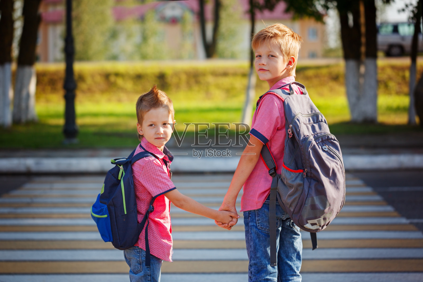 在人行横道附近画两个背着背包的可爱男孩照片摄影图片