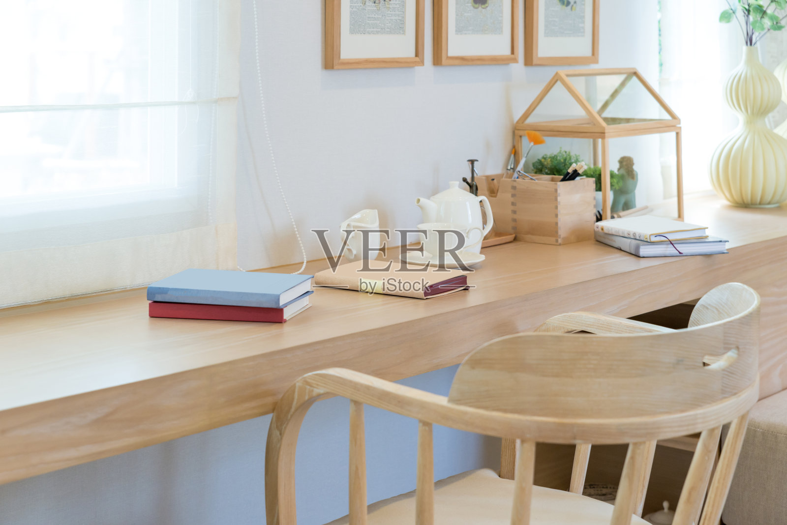 书、咖啡杯、瓶罐放在家里装饰的木桌上。读角室内房间概念。照片摄影图片