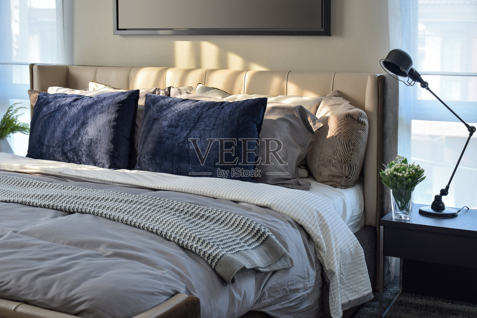 现代卧室，蓝色的枕头和黑色的灯在桌子上照片摄影图片