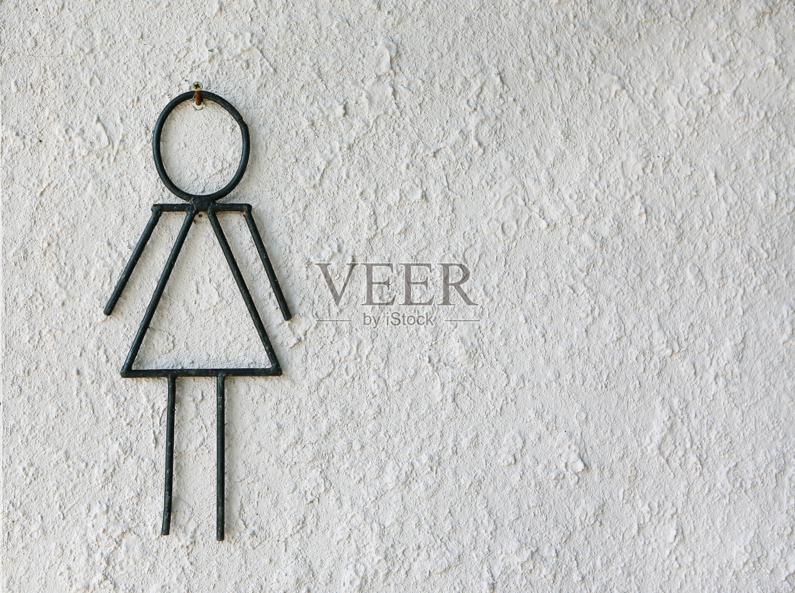 卫生间女性标志抽象的白色粗糙的水泥墙背景。照片摄影图片