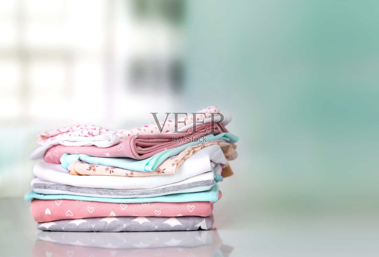 粉彩婴儿衣服堆堆空地背景。照片摄影图片