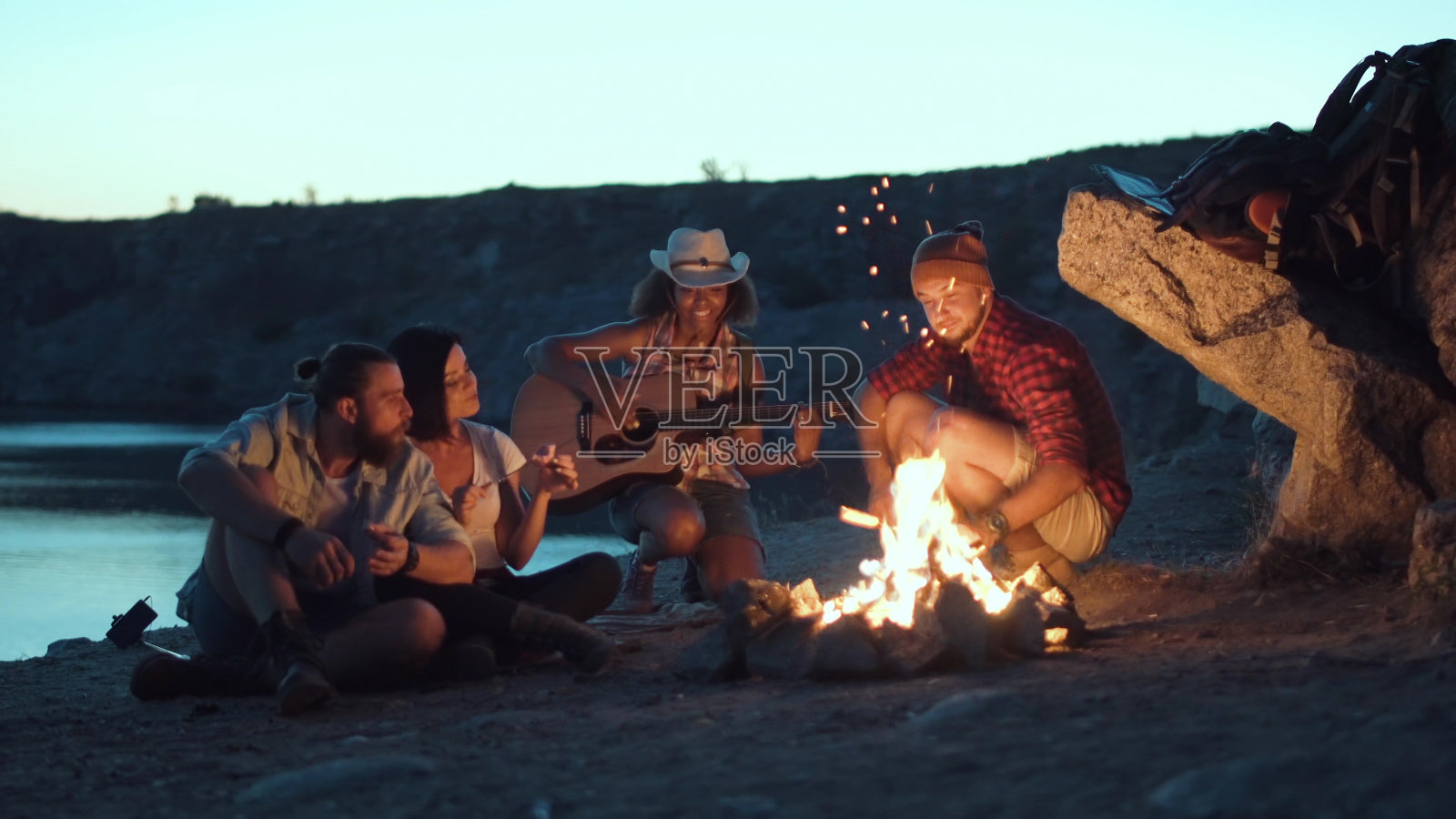 在岸边篝火旁放松的旅客照片摄影图片