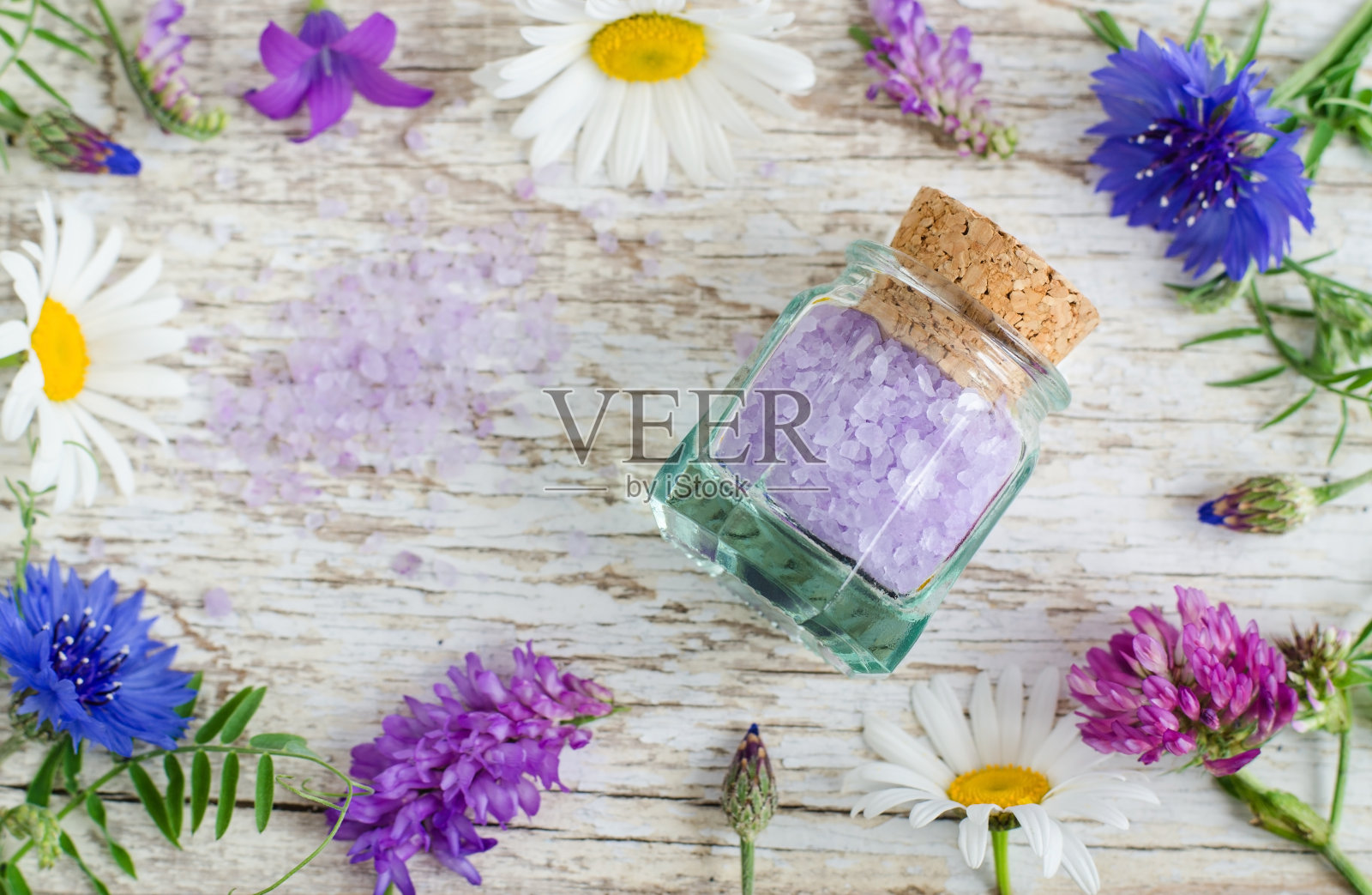 小玻璃罐芳香浴盐与花提取在木制背景。俯视图，复制空间。照片摄影图片
