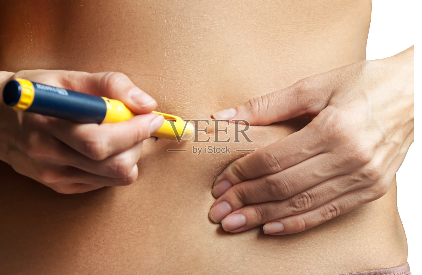 一个女人用一个注射器在胃里注射荷尔蒙。体外受精(IVF)照片摄影图片