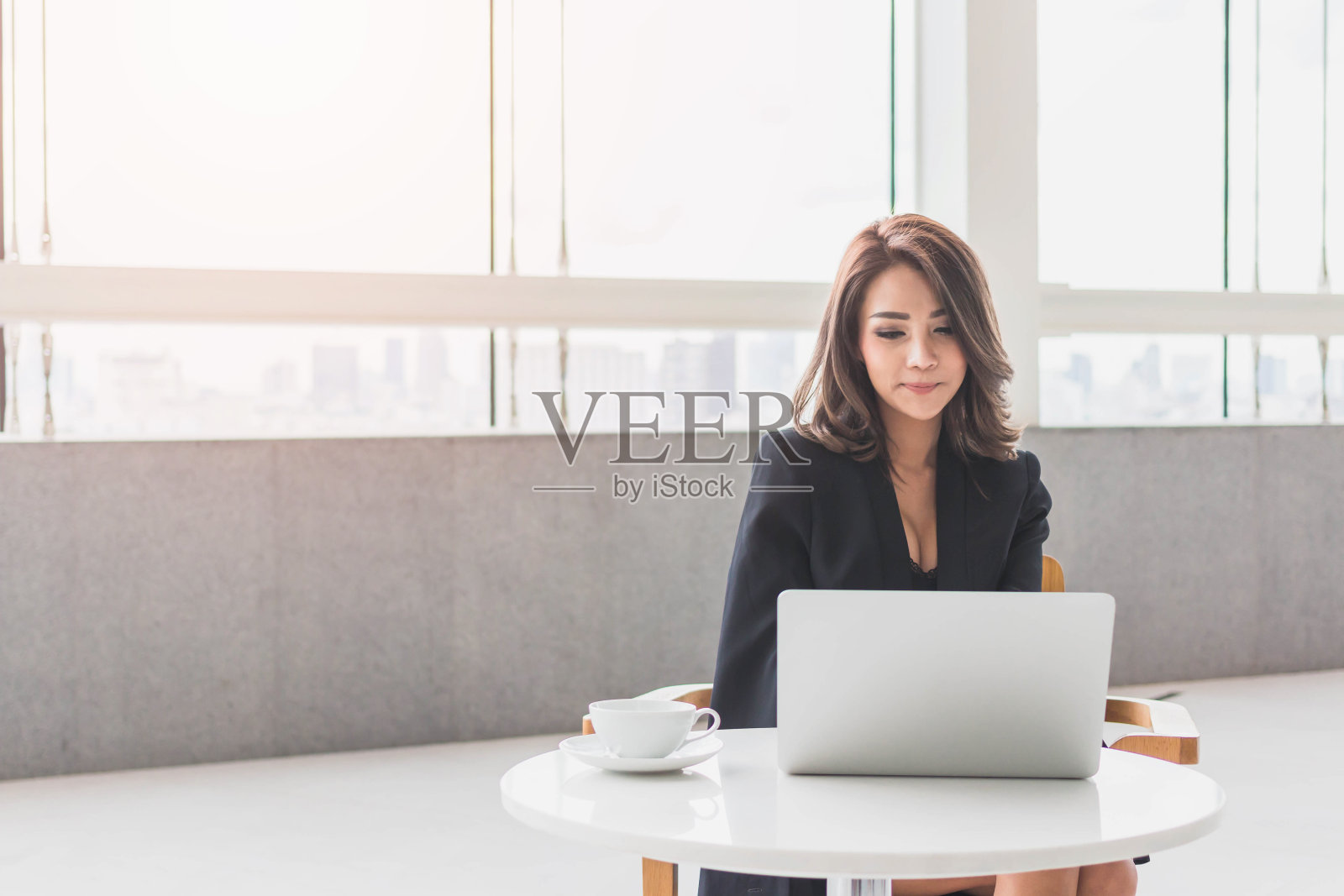美丽年轻的亚洲女孩在办公室工作，有一台笔记本电脑。精明女性创业理念。的语气照片摄影图片