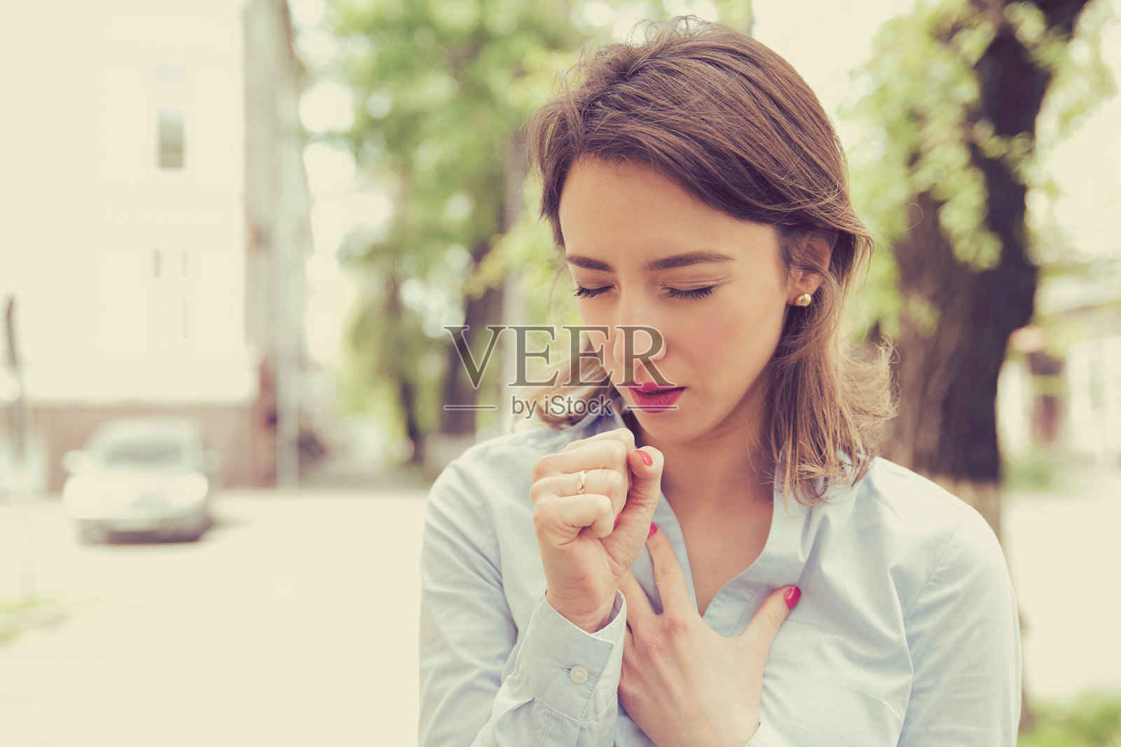 年轻妇女哮喘发作或窒息不能呼吸，因为呼吸问题站在户外城市街道上照片摄影图片