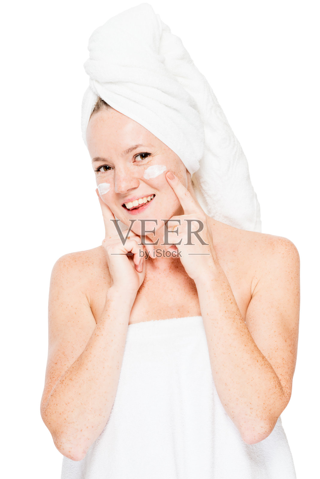 快乐的自然女人与雀斑在皮肤上应用霜后，洗澡照片摄影图片