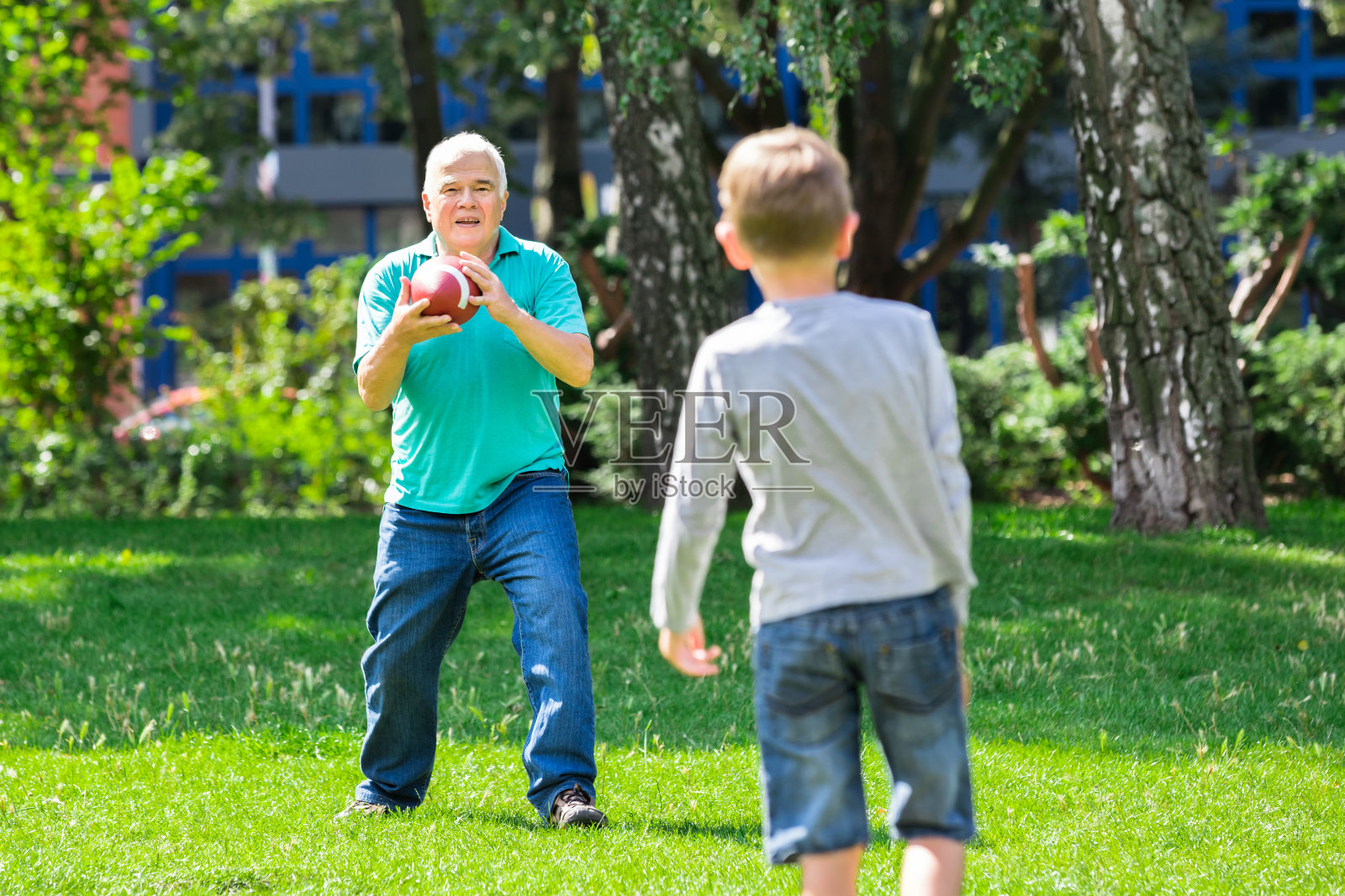 孙子和爷爷在玩橄榄球照片摄影图片