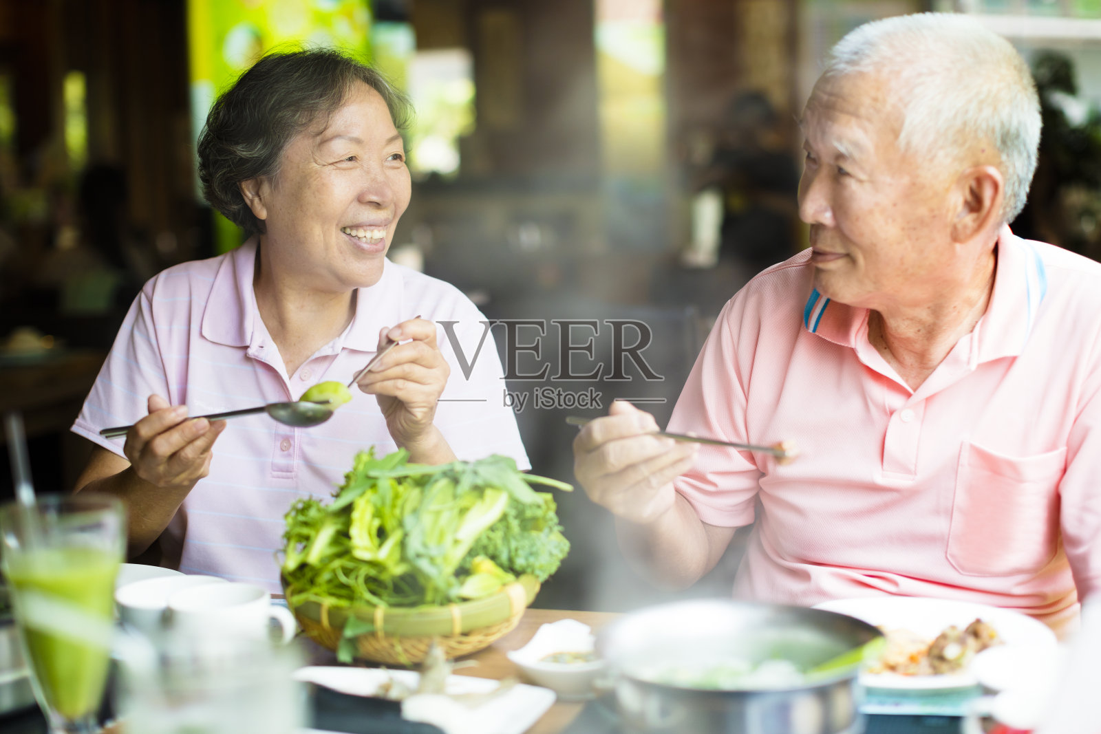 快乐的老夫妇在餐厅享用火锅照片摄影图片