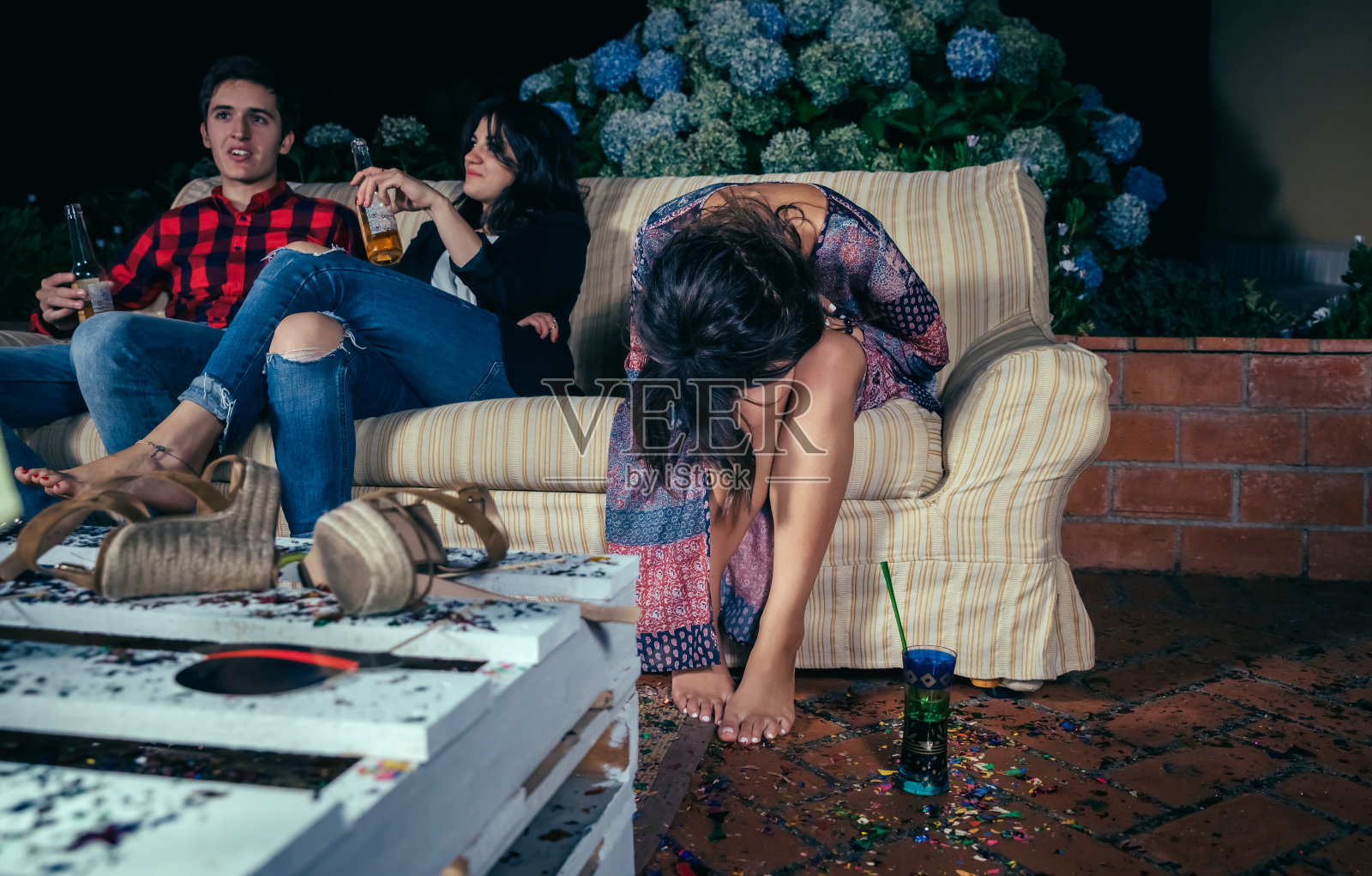 聚会上一个喝醉的年轻女人坐在沙发上照片摄影图片