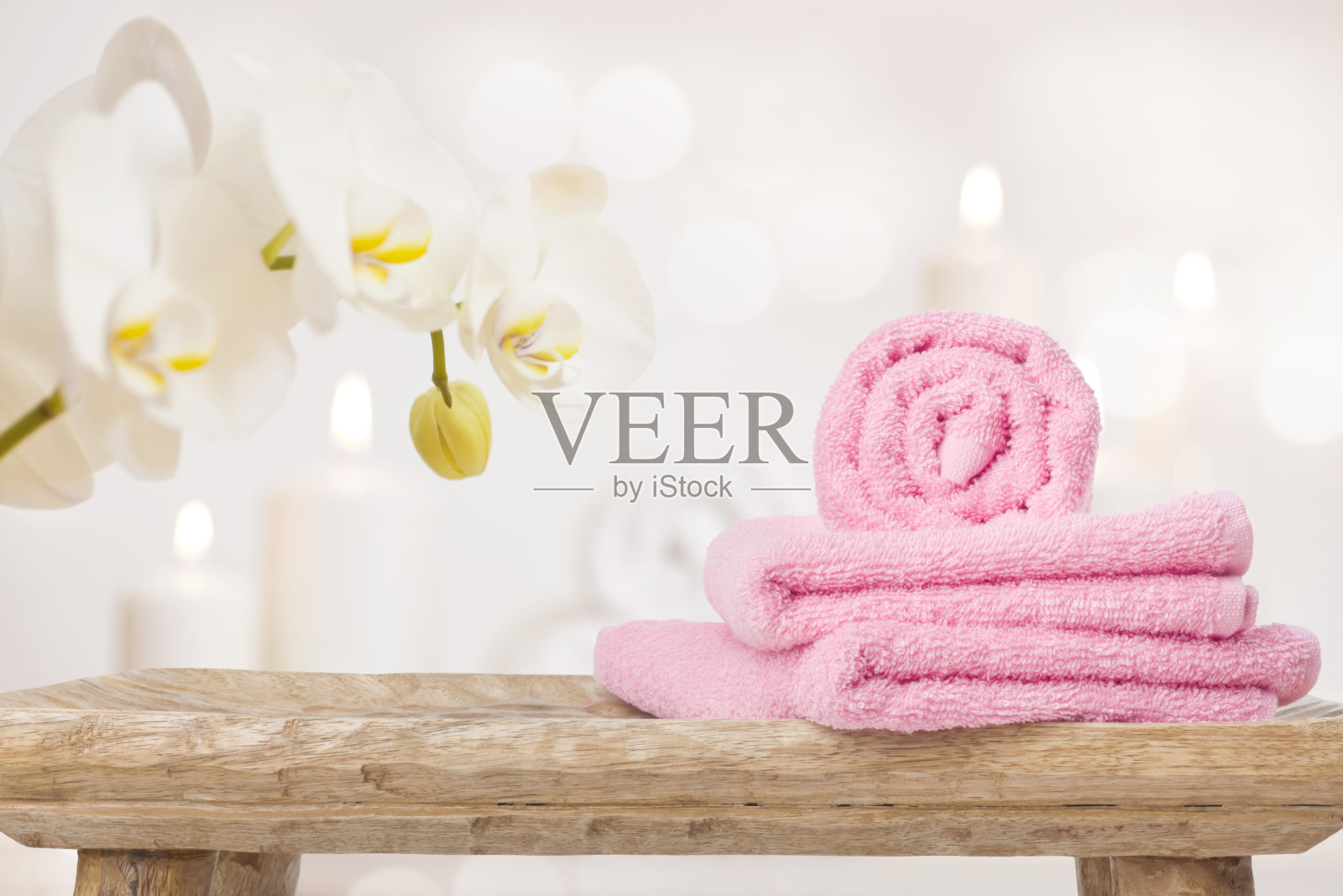 木制桌子上的温泉毛巾，抽象背景上的兰花照片摄影图片