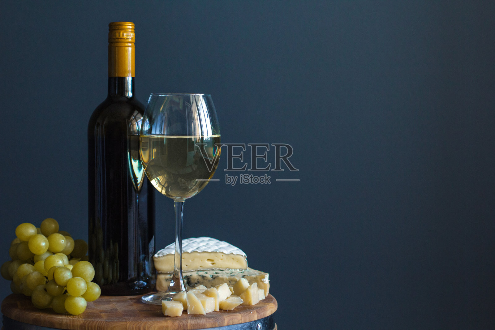 瓶子和玻璃杯与白葡萄酒靠近奶酪组成在木板上照片摄影图片