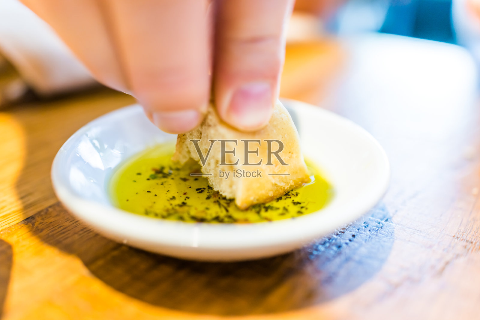 餐馆里用香草橄榄油蘸面包片的人照片摄影图片