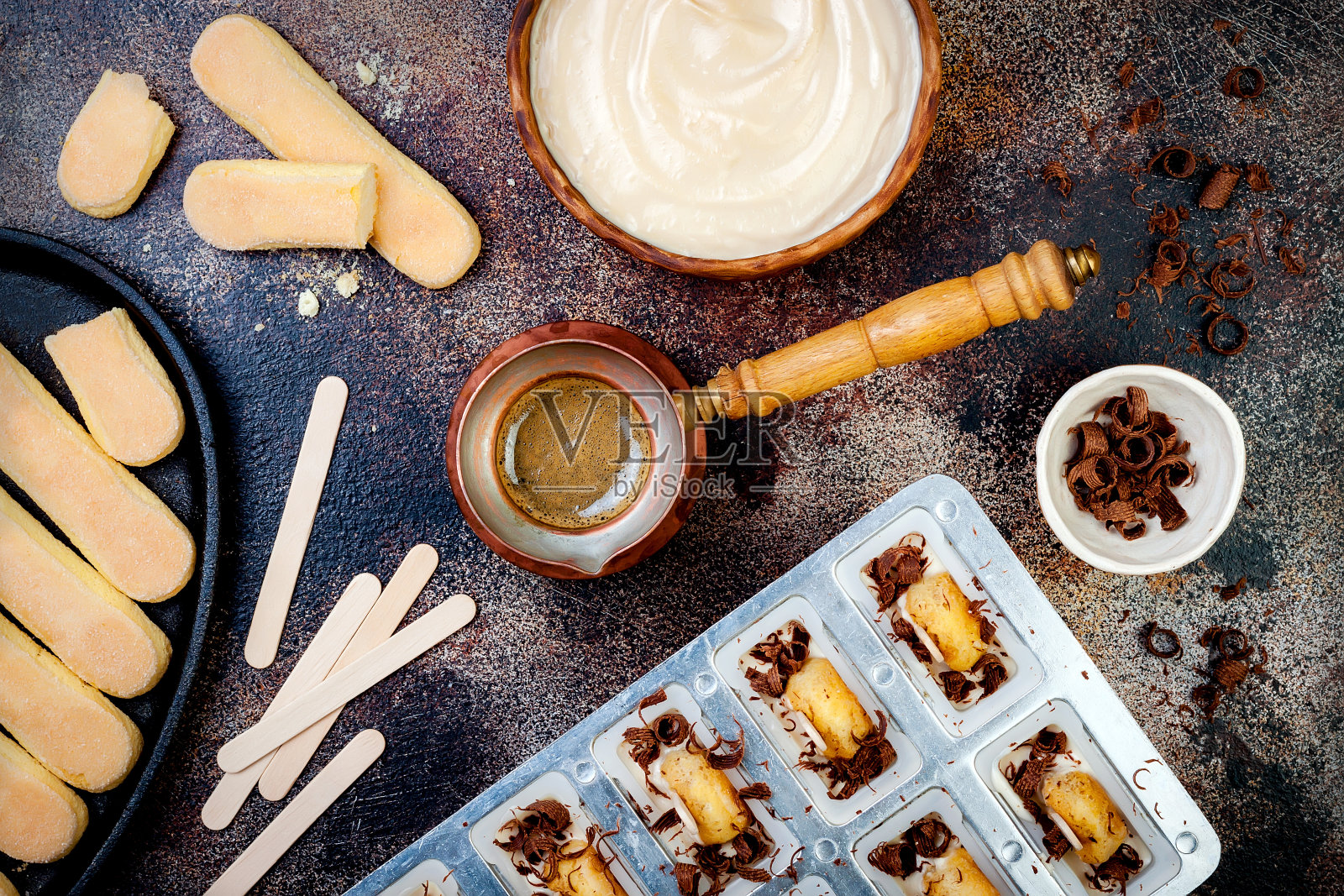 提拉米苏冰棒。用意大利savoiardi饼干和提拉米苏做成的冰棍放在质朴的餐桌上。俯视图，头顶，平躺照片摄影图片