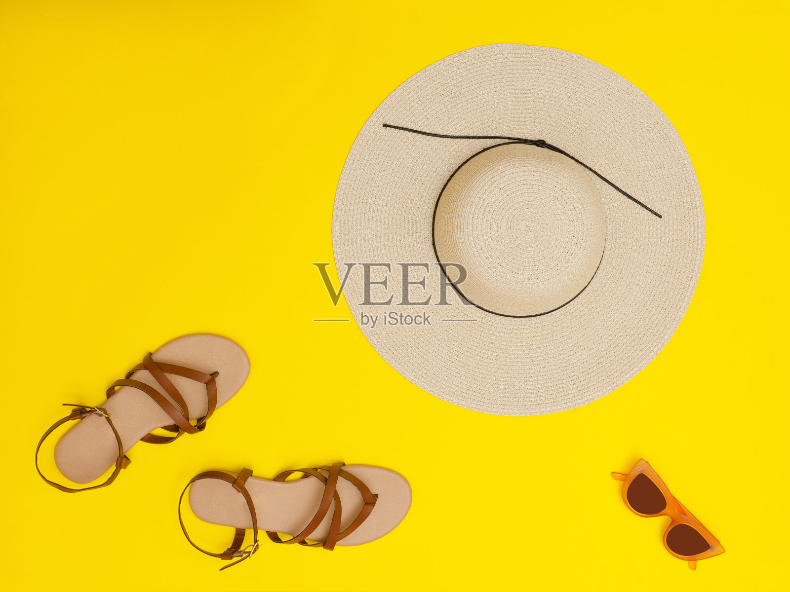 时尚的概念。女式沙滩帽，太阳镜，凉鞋。黄色背景，俯视图照片摄影图片