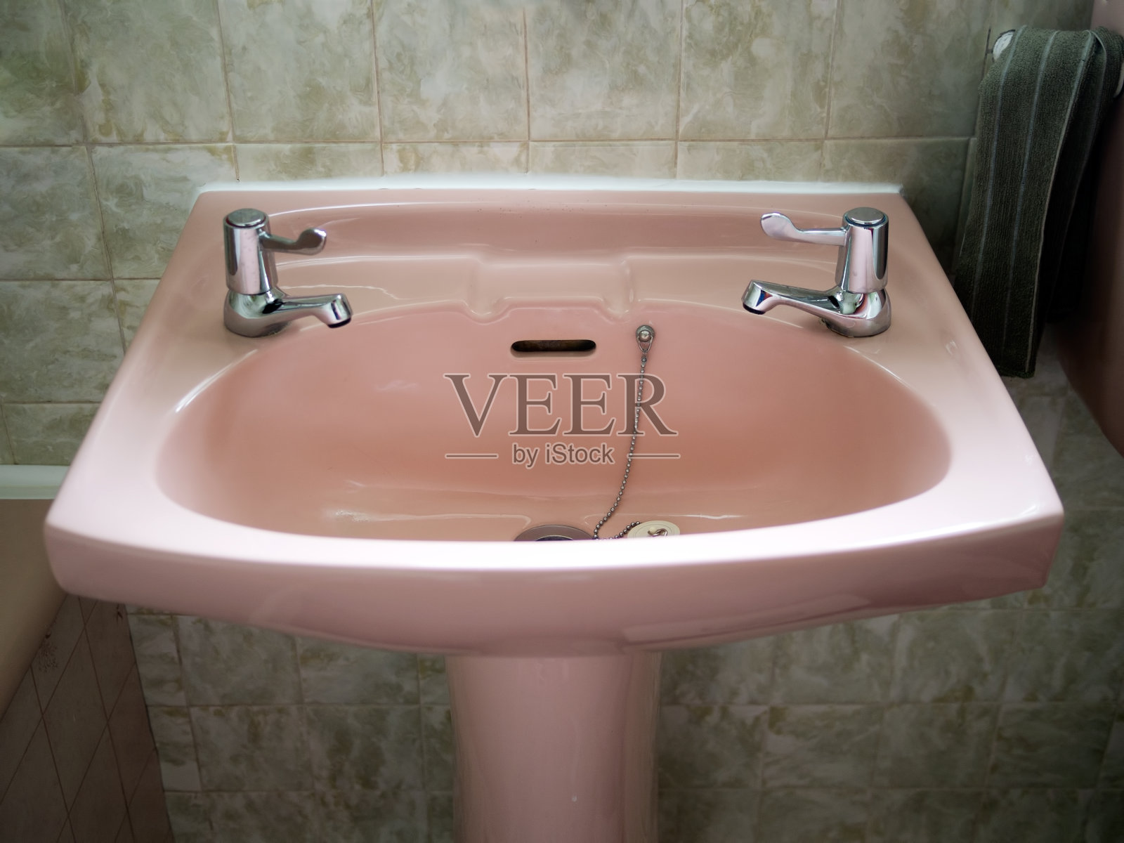 绿色浴室里的复古粉色水槽。照片摄影图片