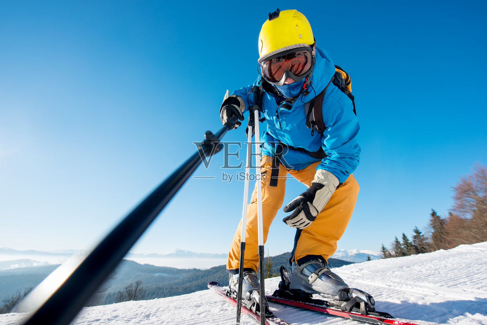 一名专业滑雪者用单脚架在山顶山坡上摆姿势自拍的低角度镜头，copyspace滑雪度假区休闲旅游旅游度假极度肾上腺素照片摄影图片