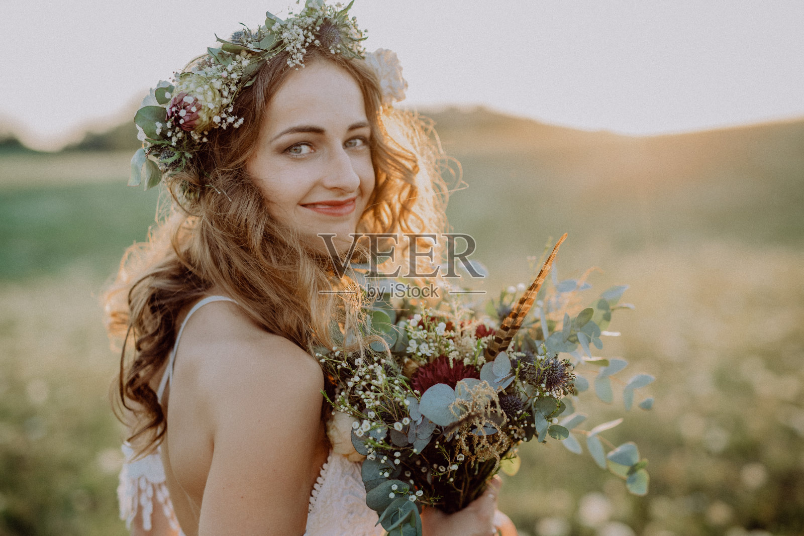 美丽的年轻新娘日落在绿色的自然。照片摄影图片