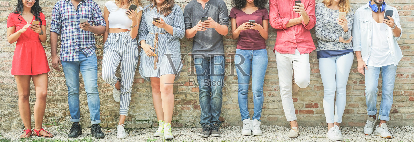 多元文化的人使用移动智能手机户外-快乐的朋友与科技趋势的乐趣-年轻，新一代成瘾和友谊的概念-温暖过滤照片摄影图片