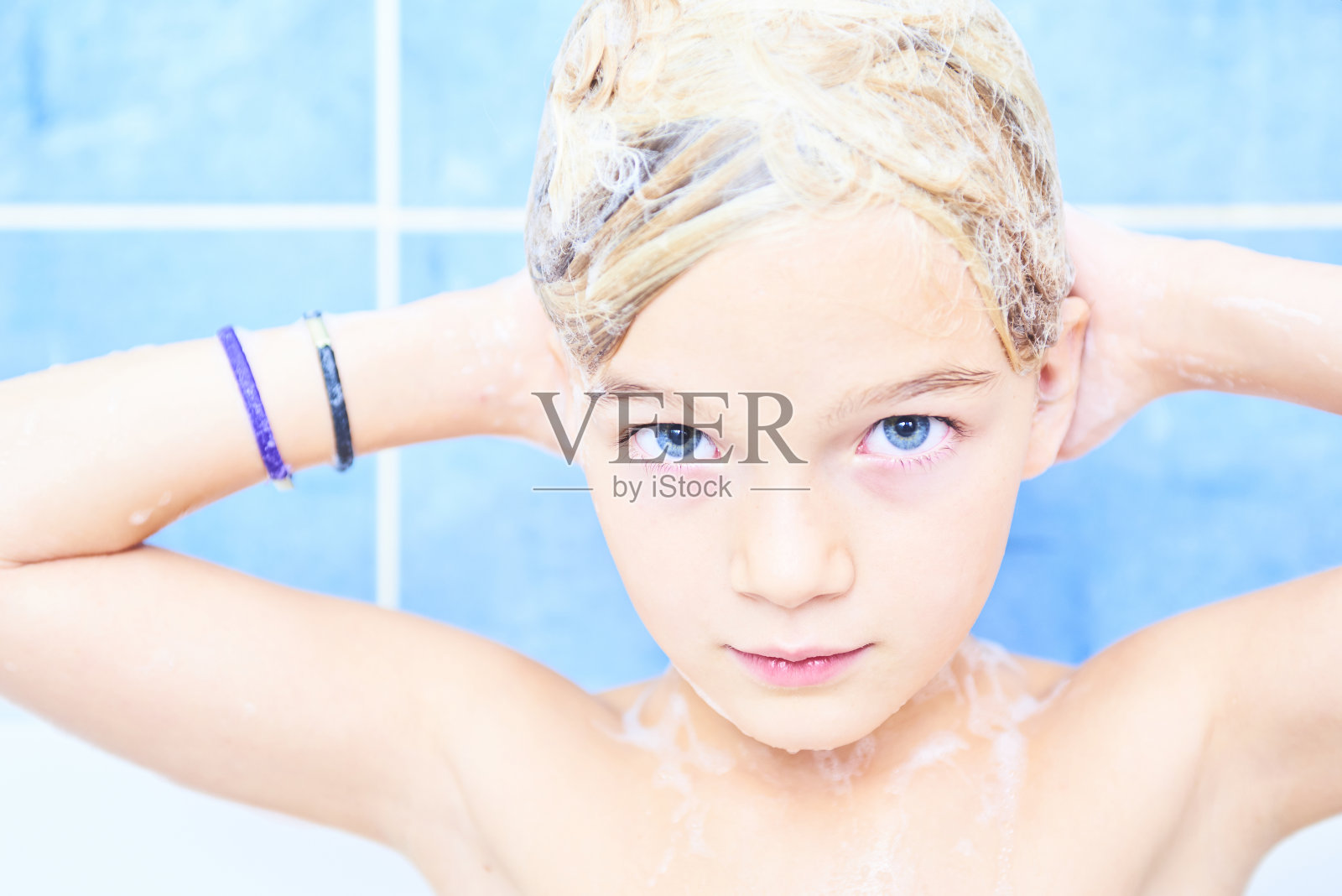 可爱的金发小女孩用洗发水泡沫洗澡。照片摄影图片