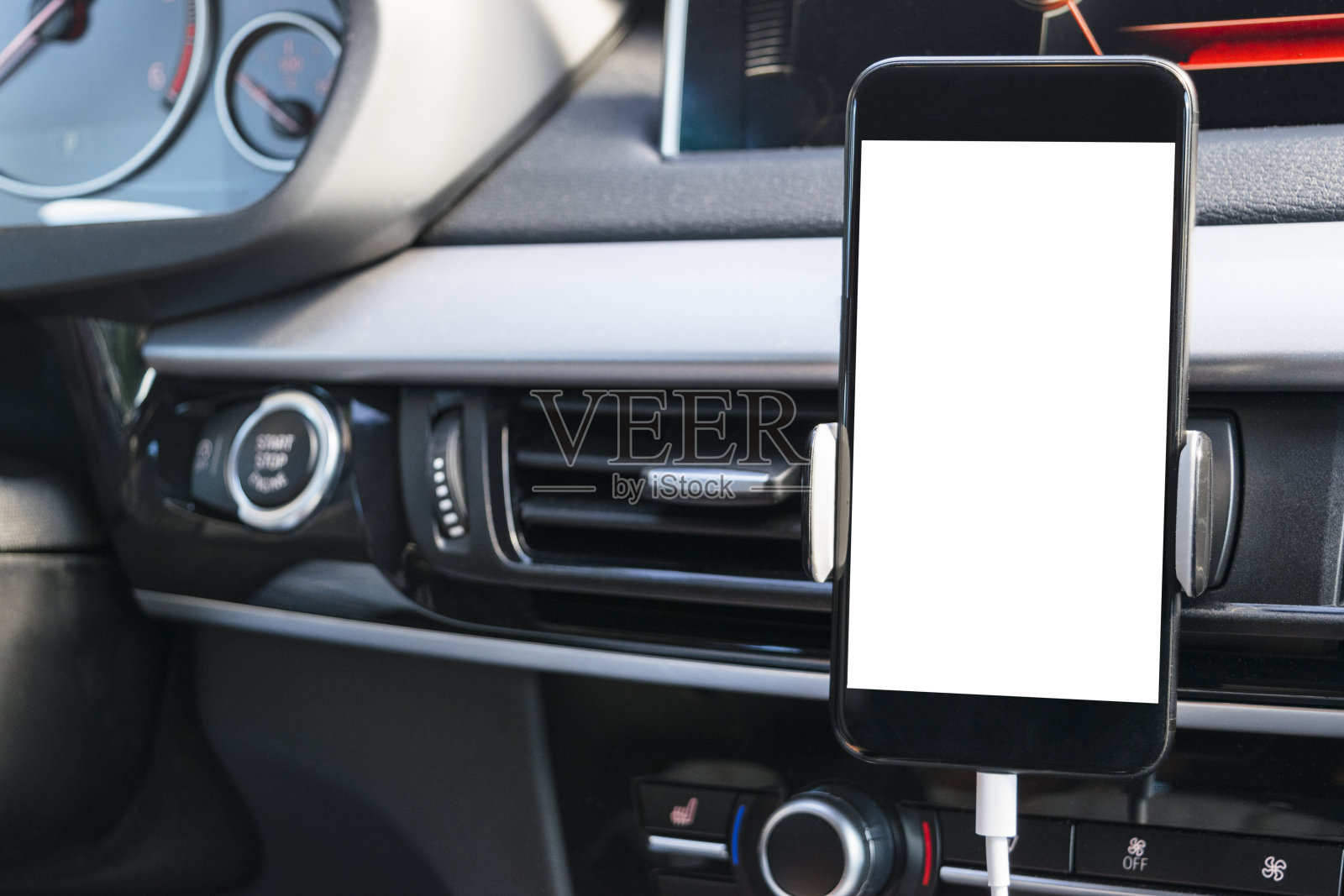 智能手机在汽车中使用导航或GPS。驾驶一辆装有智能手机的汽车。手机与孤立的白色屏幕。空白的空屏幕。副本的空间。文本的空白。现代汽车内部细节。照片摄影图片