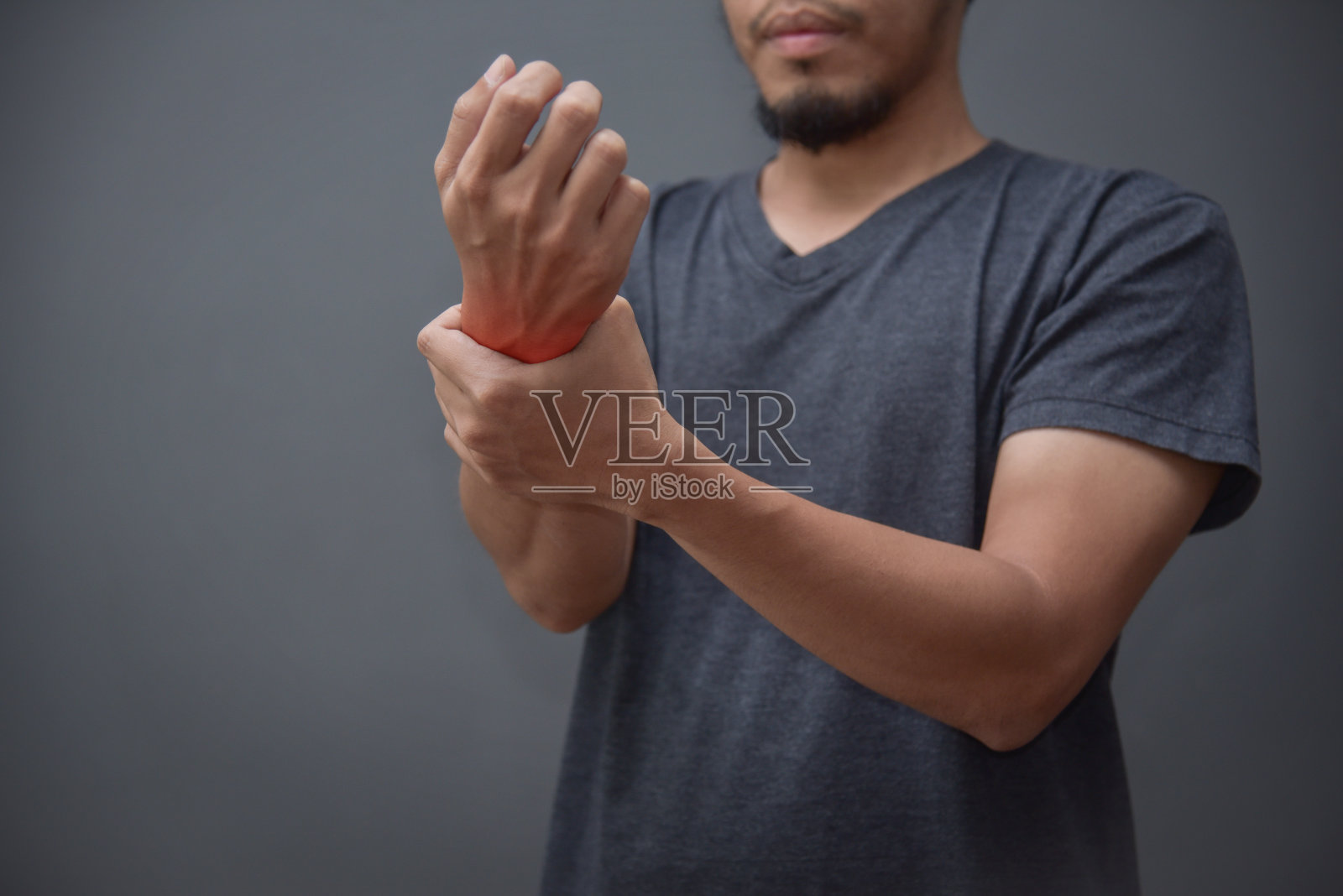 手腕疼痛的亚洲胡子男人。照片摄影图片