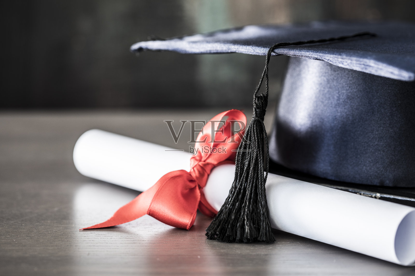 毕业帽和毕业证书放在桌子上照片摄影图片
