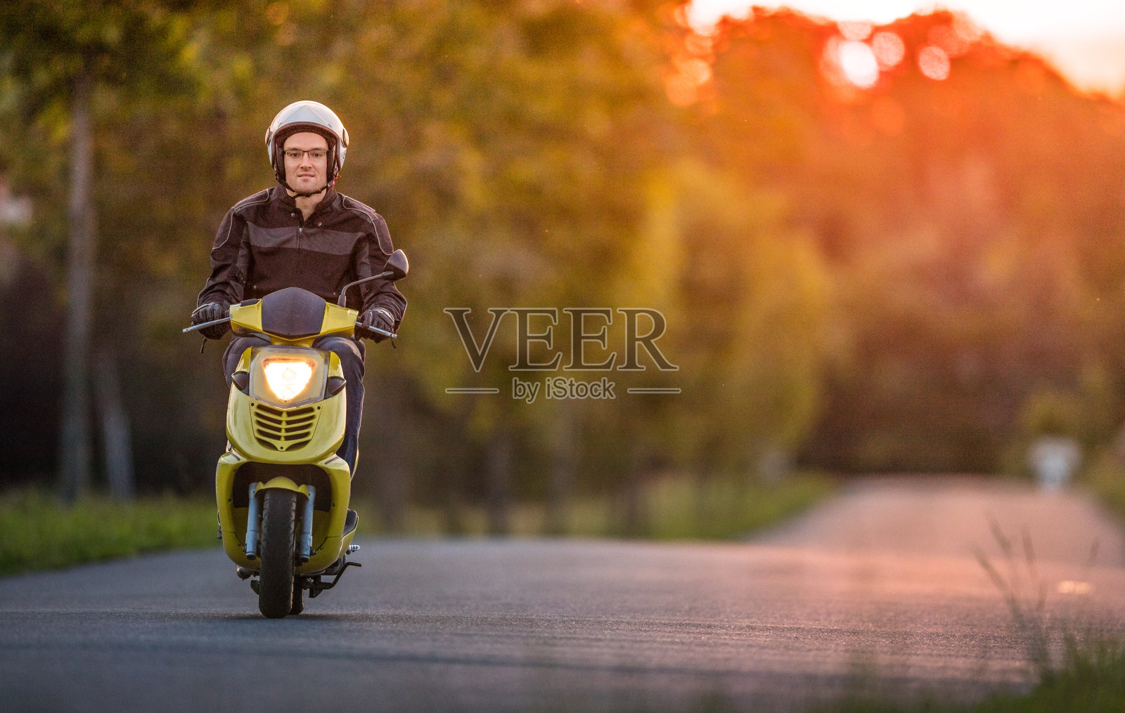 夕阳下骑摩托车的人照片摄影图片