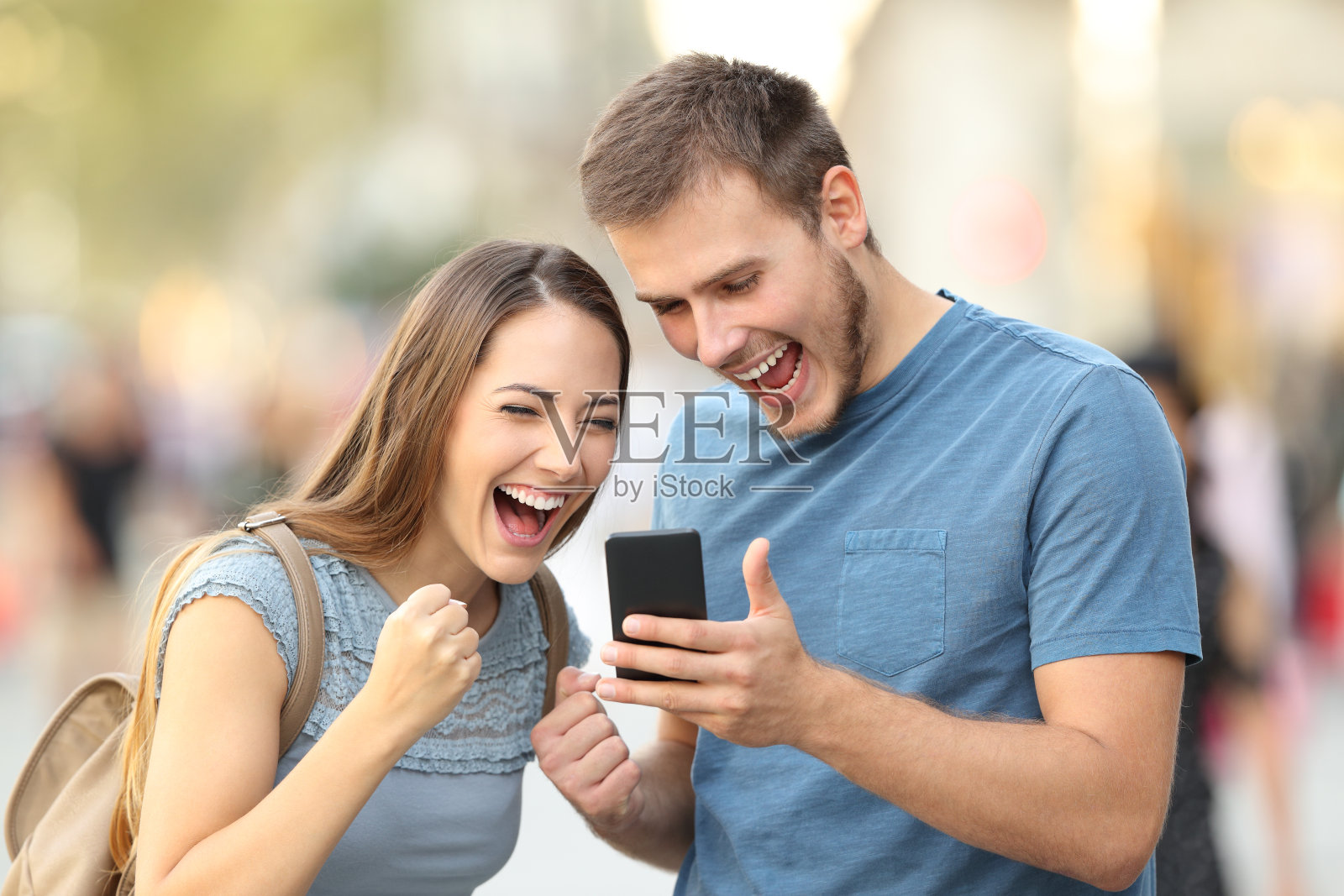 一对激动的夫妇在外面收到了好消息照片摄影图片