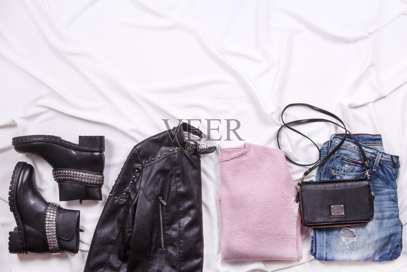 秋冬时尚博主的行头。粉色羊毛针织开衫，蓝色牛仔布和黑色包。照片摄影图片