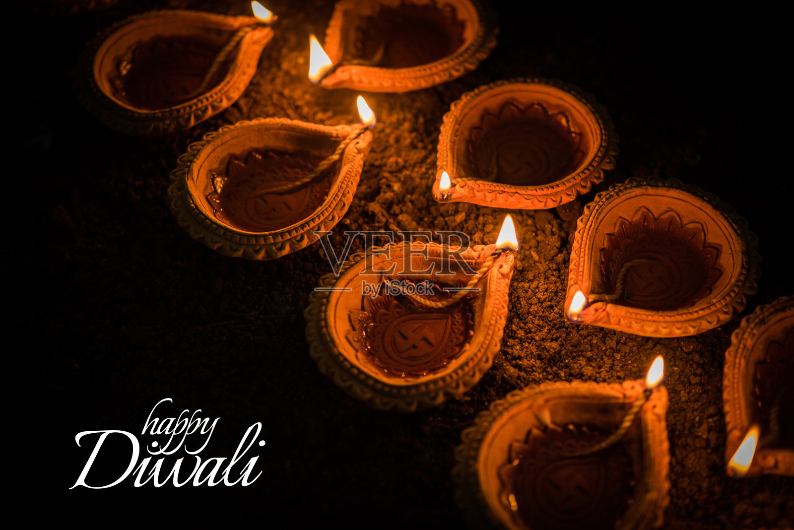 快乐的排灯节贺卡设计使用美丽的粘土diya灯在排灯节之夜庆祝。印度灯节称为排灯节，一个光的节日照片摄影图片
