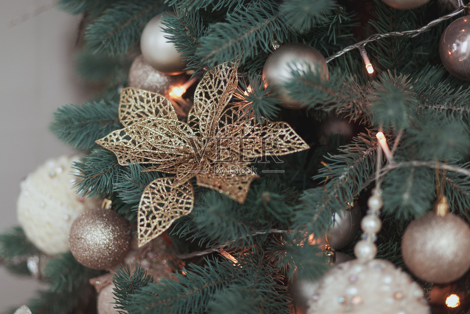 花圣诞树装饰，黄金光泽的装饰集，挂在冷杉球和花环照片摄影图片