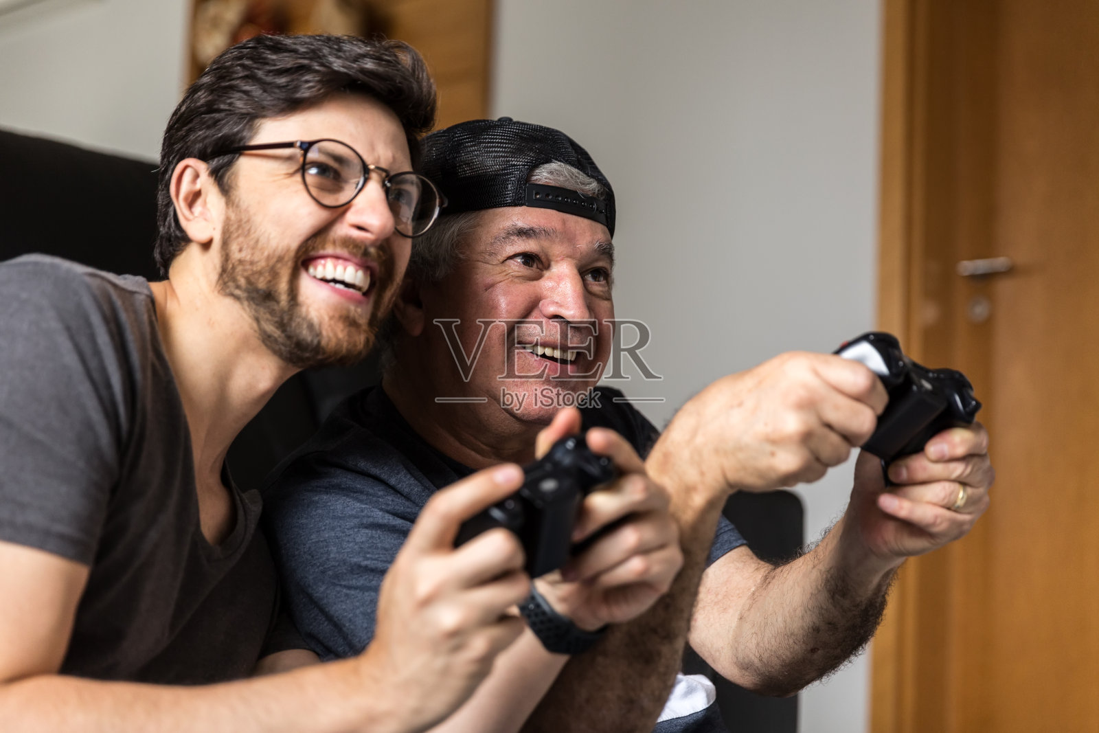 爸爸和儿子在家里玩电子游戏照片摄影图片