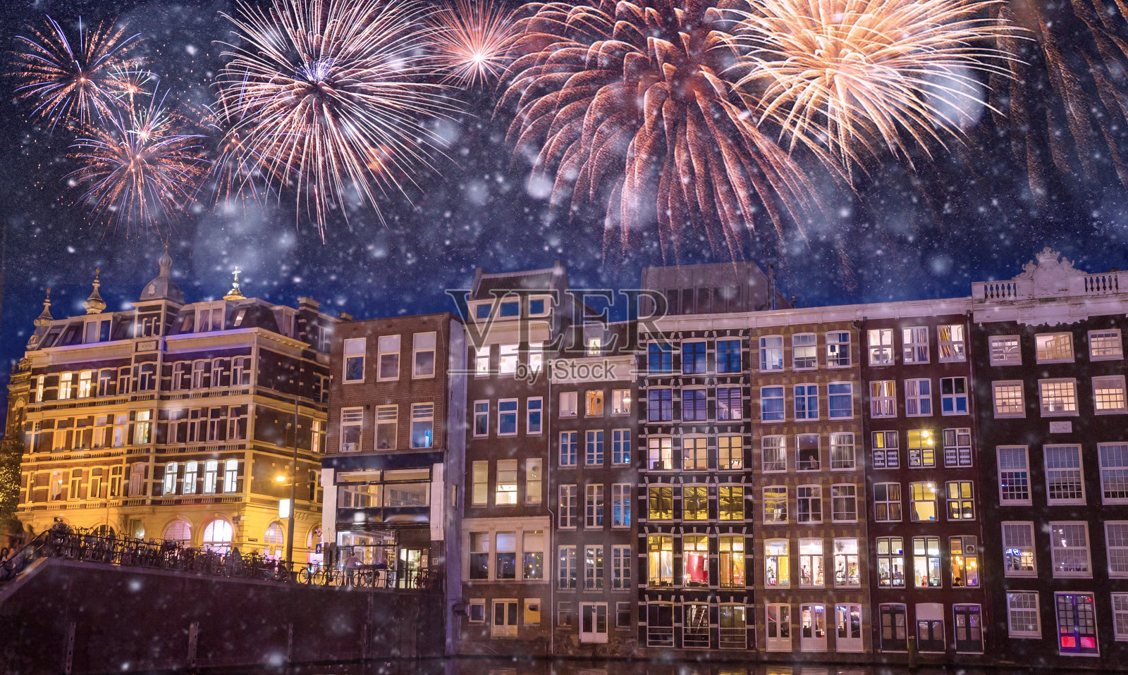 荷兰阿姆斯特丹，传统的老建筑和船只在夜晚的黑色天空上燃放烟花照片摄影图片