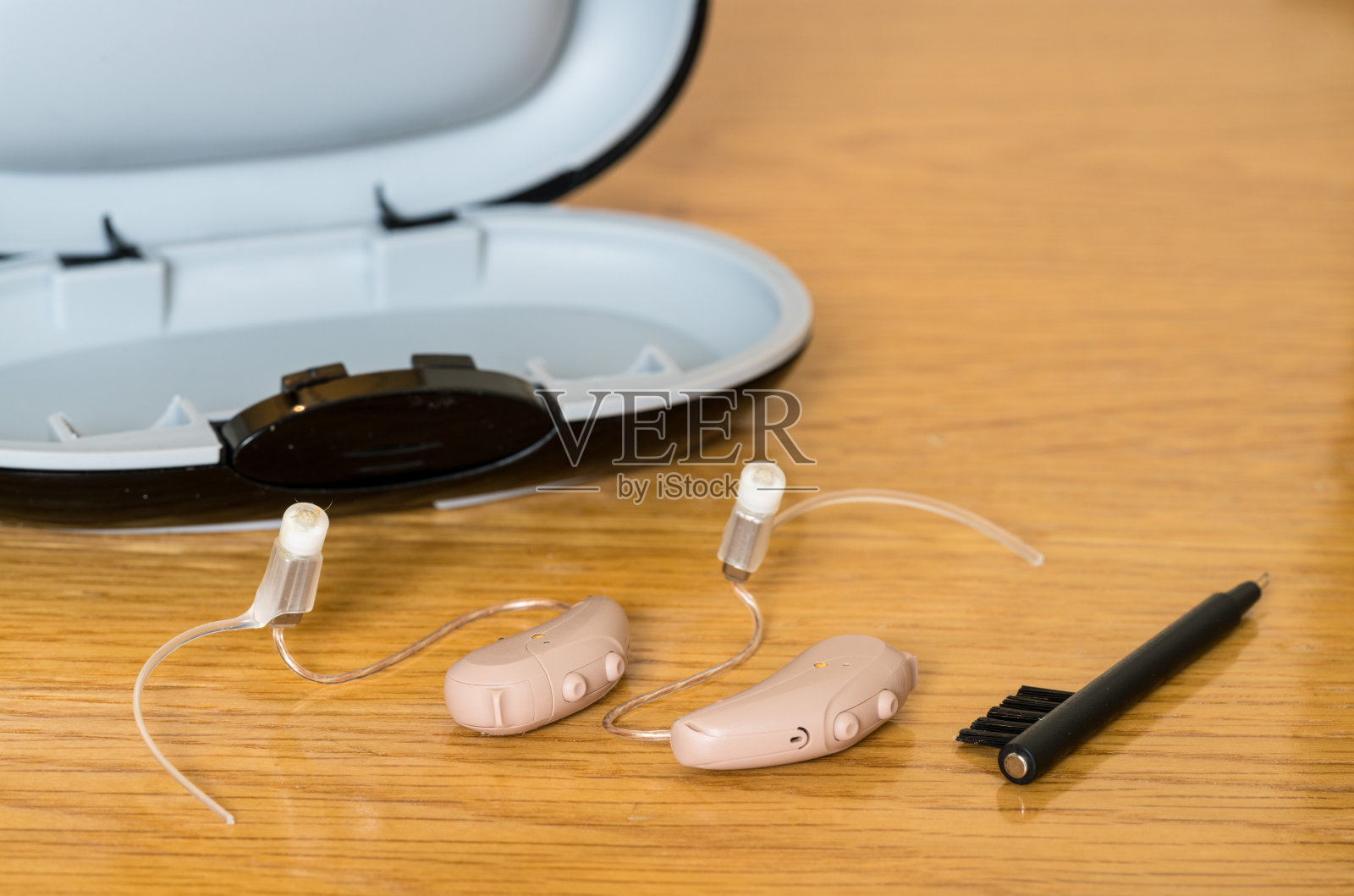 床头柜上的一对微型现代助听器的特写照片摄影图片