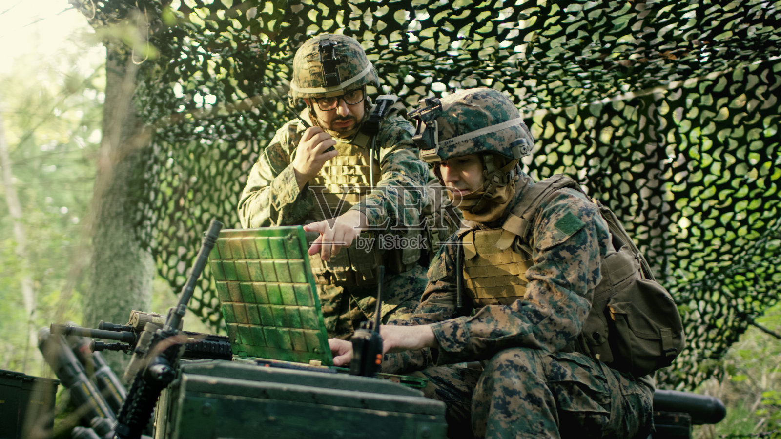 军事集结基地，总工程师使用无线电和陆军级笔记本电脑。森林业务/任务正在进行中。照片摄影图片