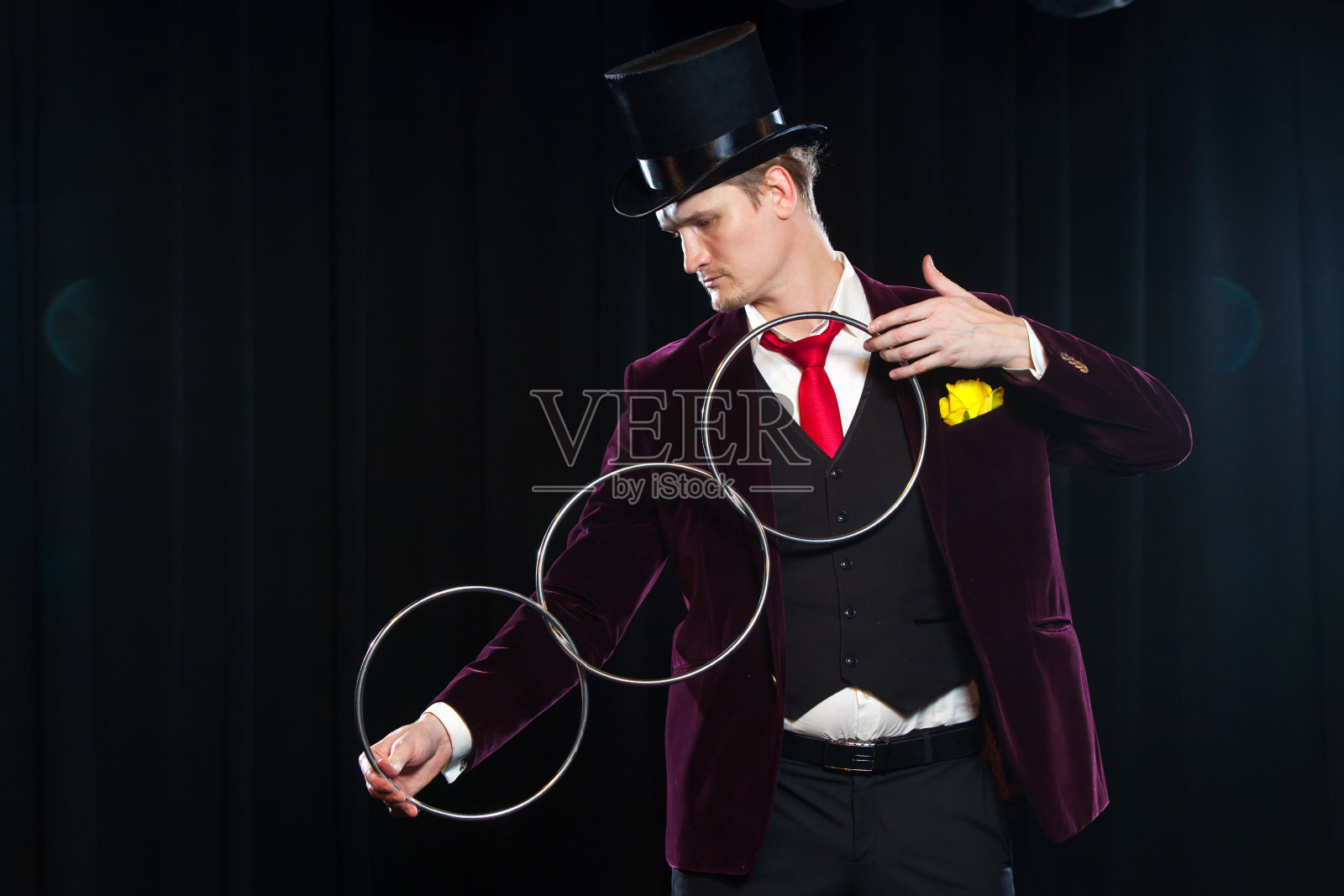 魔术，表演，马戏团，表演的概念-魔术师在大礼帽展示魔术与连接环照片摄影图片