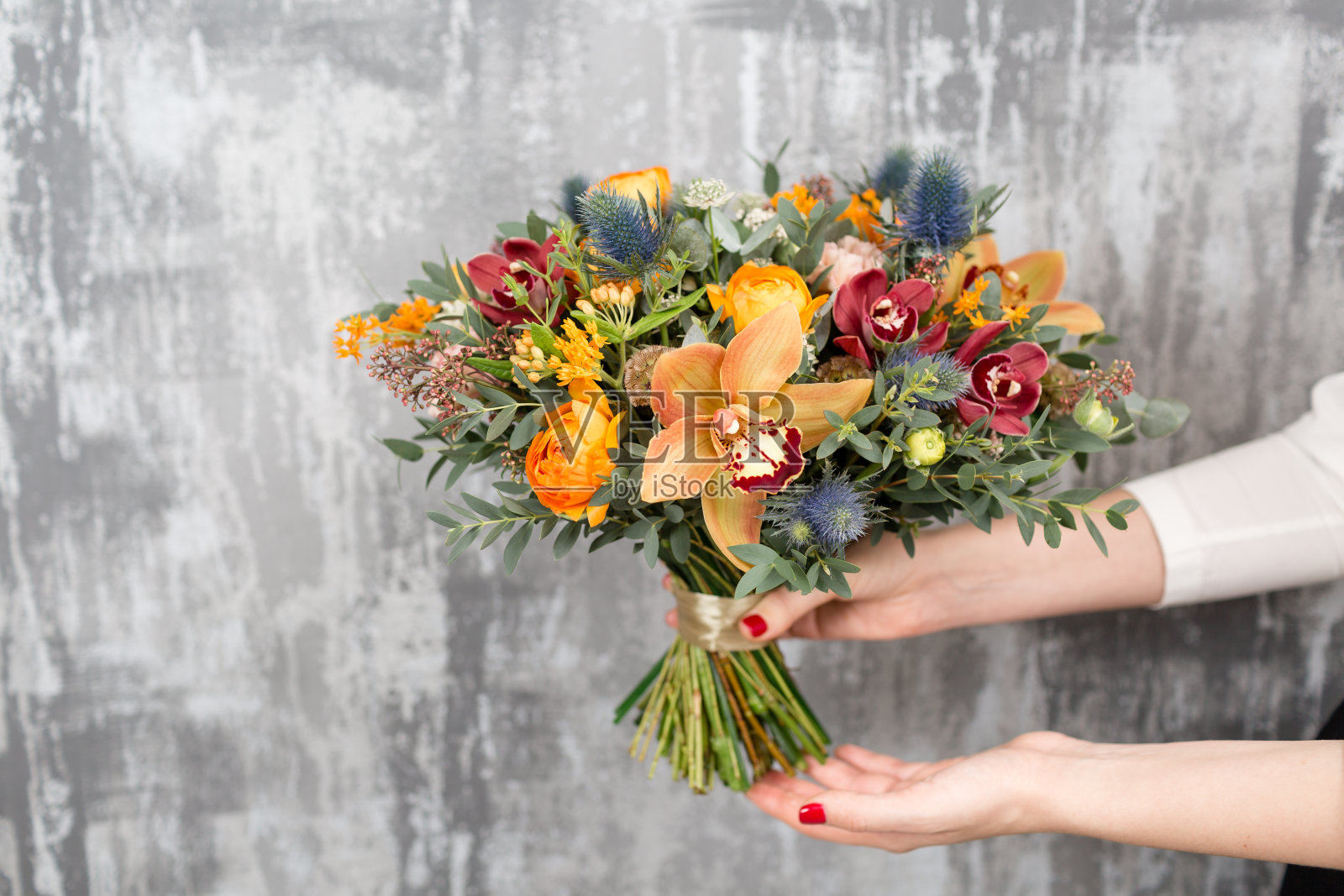 美丽的婚礼花束混合鲜花在女人的手中。花店花匠的工作照片摄影图片