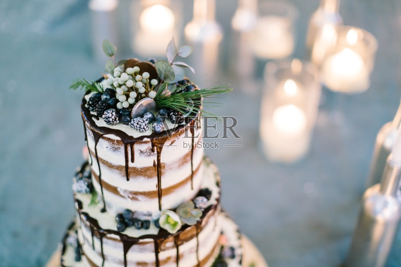 装修、engagement、treatment的概念。接近美味的蛋糕顶部，为庆祝婚礼，令人惊讶的装饰花卉元素，黑莓和糖霜照片摄影图片