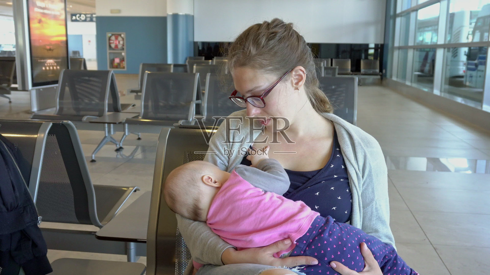 一名妇女在机场哺乳她的孩子照片摄影图片