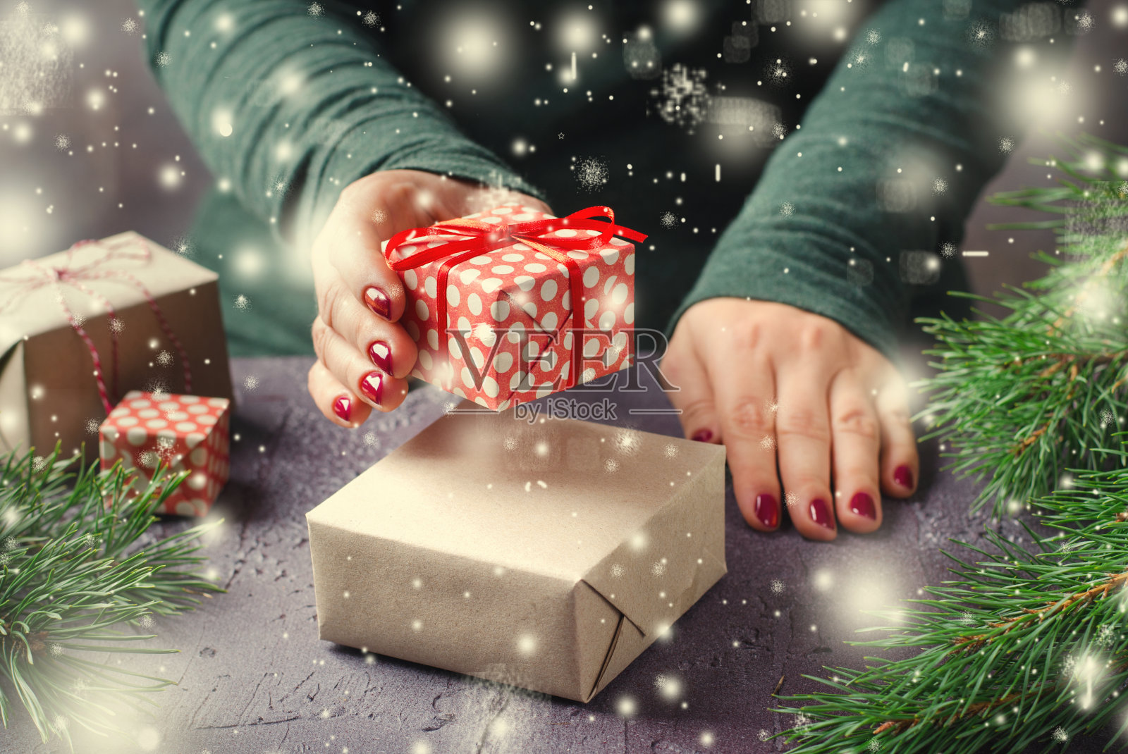 女性的手包装和礼物的圣诞礼物在黑暗的背景照片摄影图片