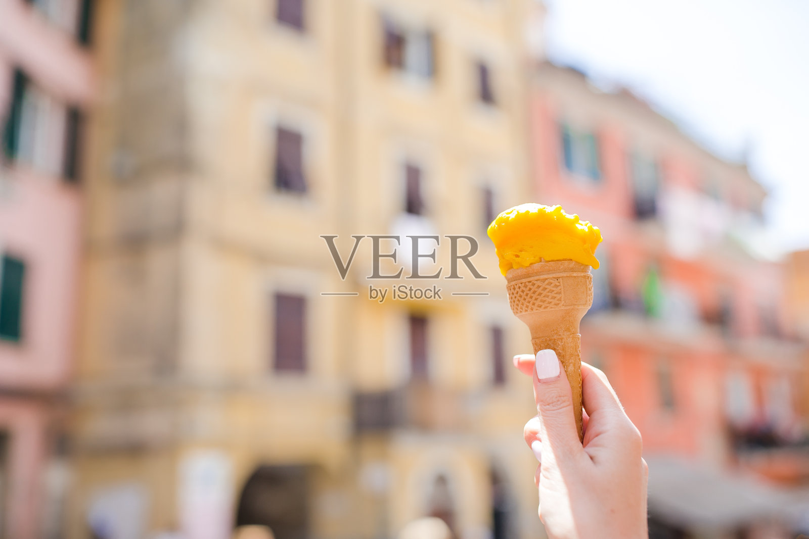 美味的甜冰淇淋特写在女性的手背景老意大利村庄照片摄影图片
