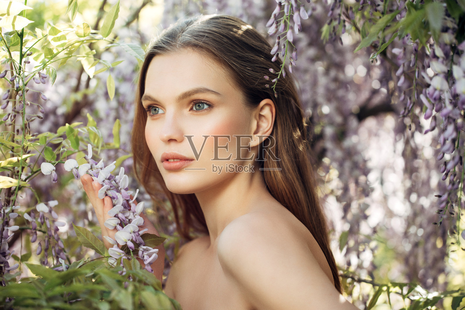 春天灌木丛背景上的美丽女孩照片摄影图片