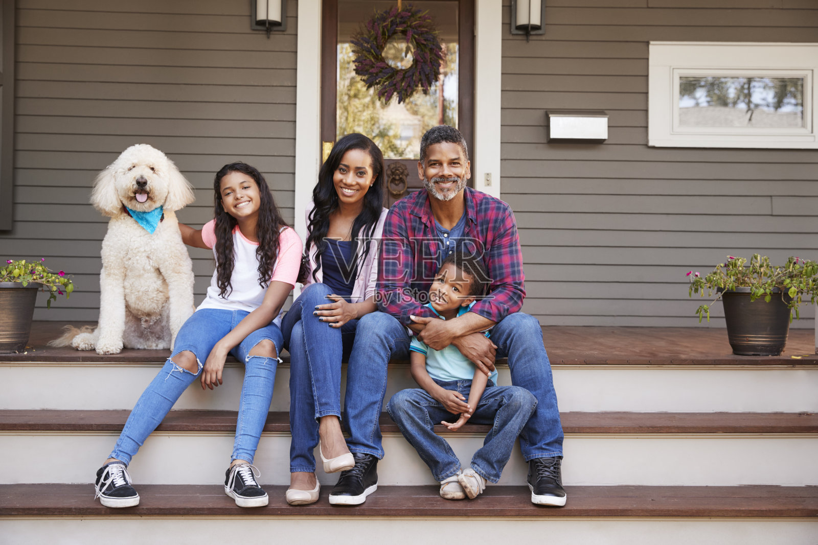 家庭和孩子和宠物狗坐在家里的台阶上照片摄影图片
