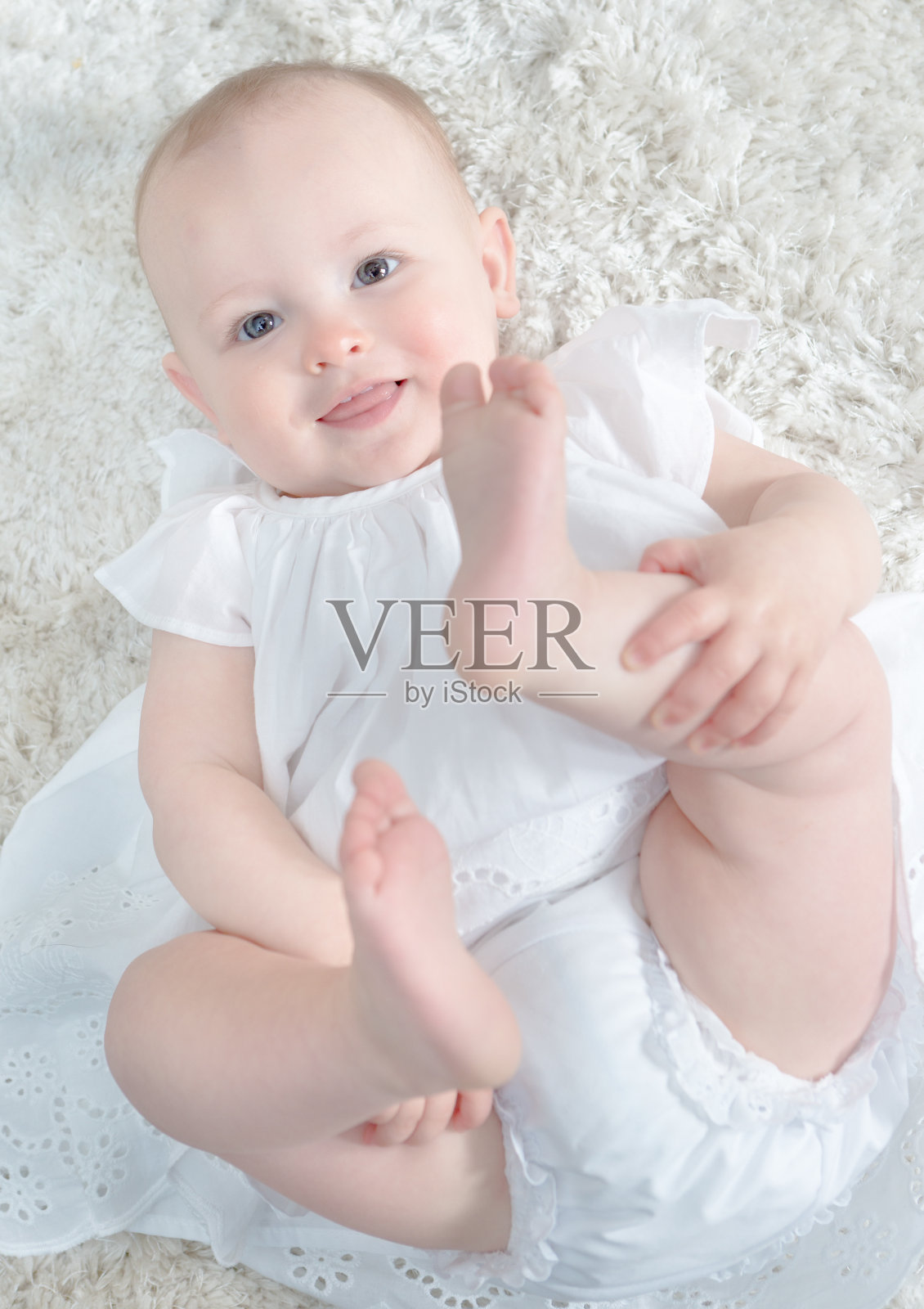 快乐的10个月大的婴儿肖像在快乐的婴儿姿势照片摄影图片