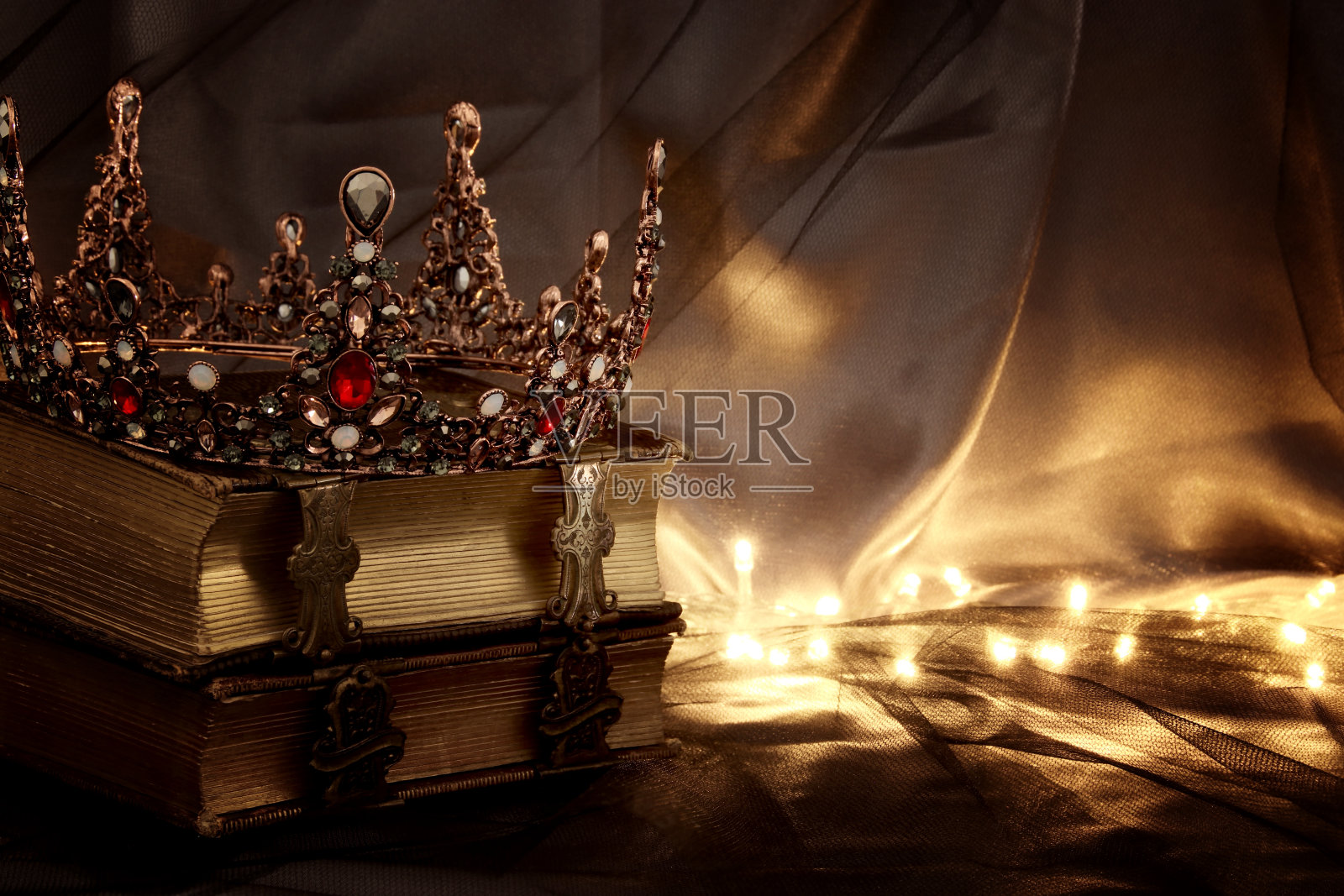 在旧书上美丽的女王/国王王冠的低调形象。幻想中世纪。照片摄影图片